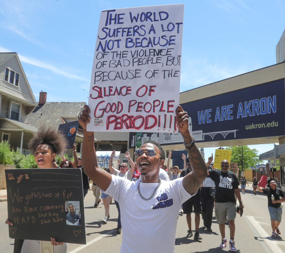 People carry signs along a street.