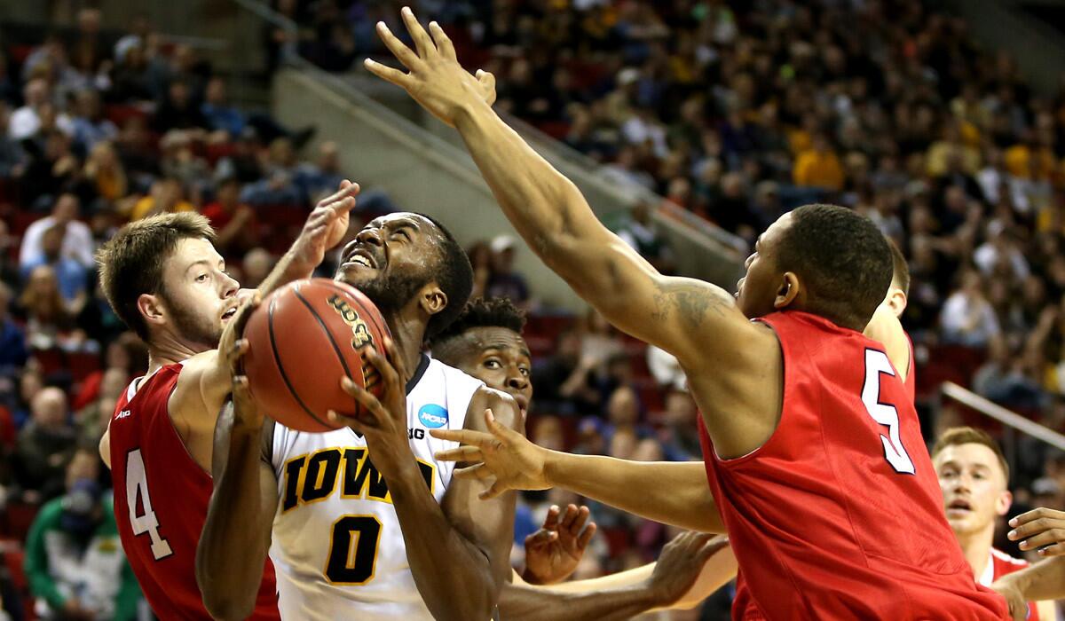 Iowa's Gabriel Olaseni prepares for a shot against Davidson's Tyler Kalinoski, left, and Jordan Barham in the first half of the Hawkeyes' 82-53 victory at KeyArena on Friday.