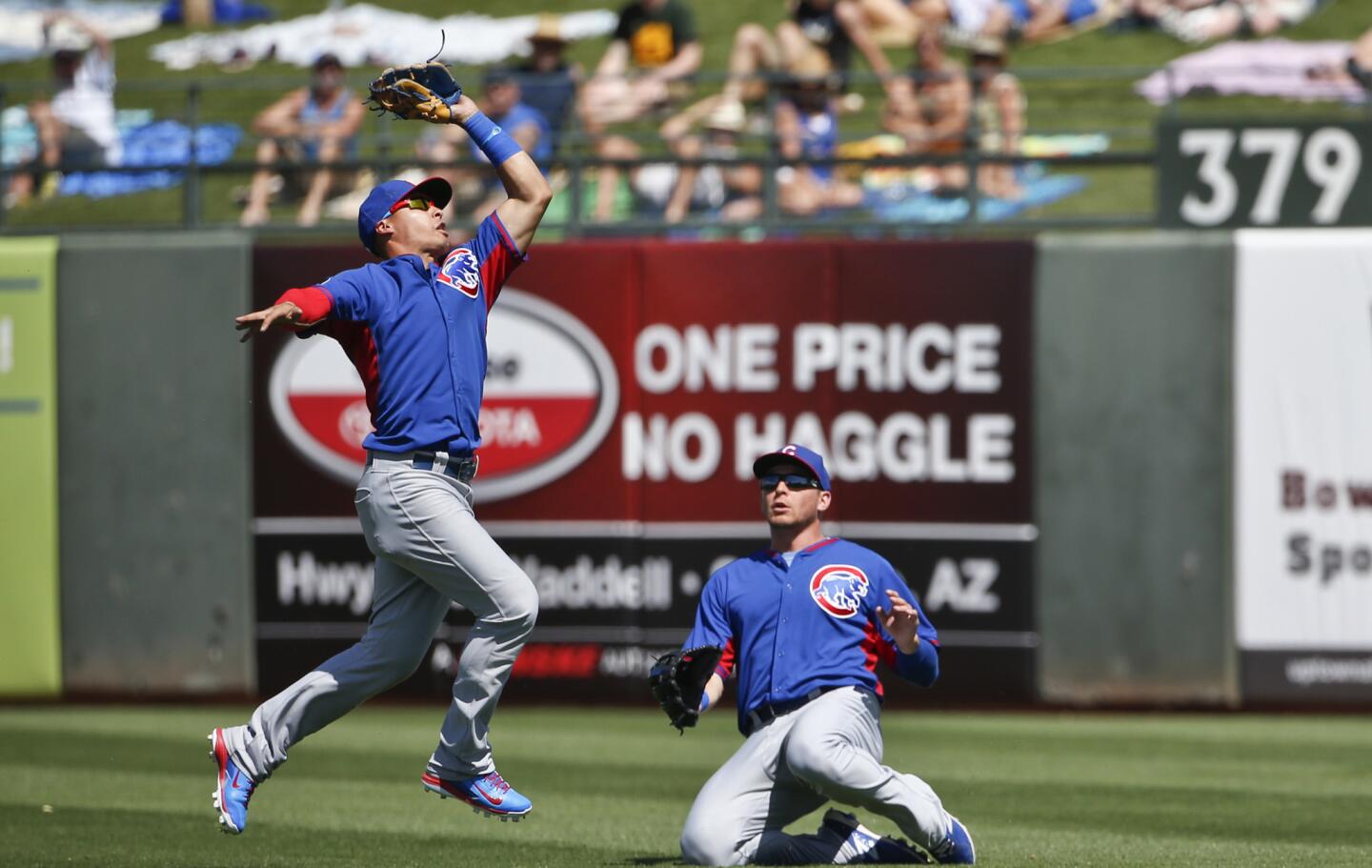 Second baseman Javier Baez makes a running catch as right fielder Ryan Sweeney ducks to avoid a collision during the second inning.