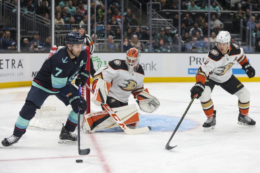 Seattle Kraken right wing Jordan Eberle (7) moves the puck as Anaheim Ducks goaltender Lukas Dostal (1) and defenseman Cam Fowler defend during the first period of an NHL hockey game Thursday, March 30, 2023, in Seattle. (AP Photo/Jason Redmond)