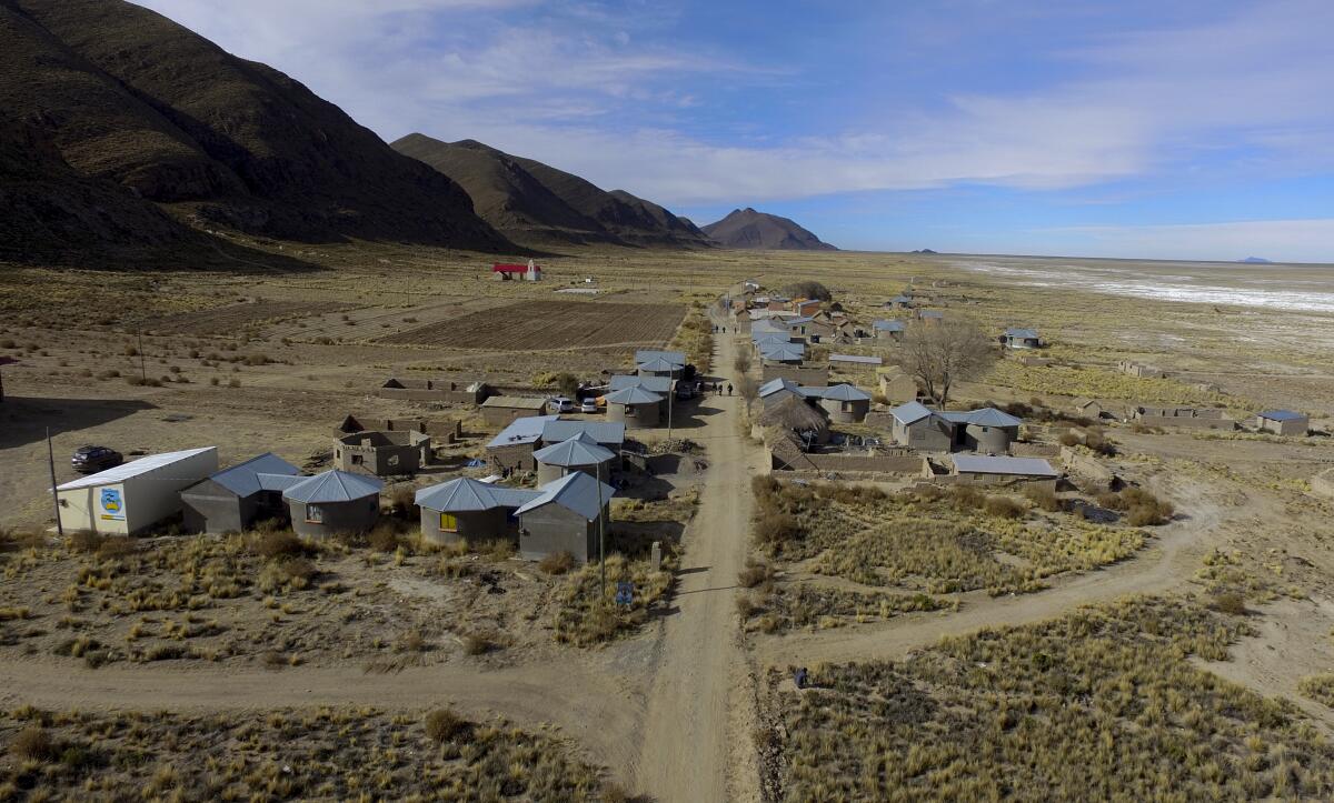 Residents walk along a dirt road in the Urus del Lago Poopo indigenous community, which sits along the salt-crusted former shoreline of Lake Poopo, in Punaca, Bolivia, Monday, May 24, 2021. Bolivia's second-largest lake dried up about five years ago, victim of shrinking glaciers, water diversions for farming and contamination. (AP Photo/Juan Karita)