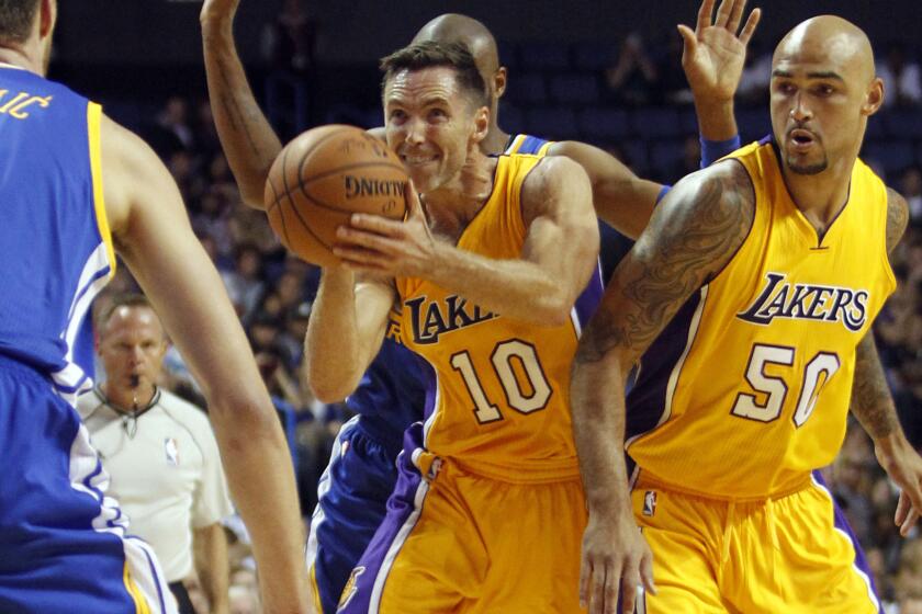 Lakers guard Steve Nash, center, puts up a shot in front of teammate Robert Sacre during a preseason loss to the Golden State Warriors.