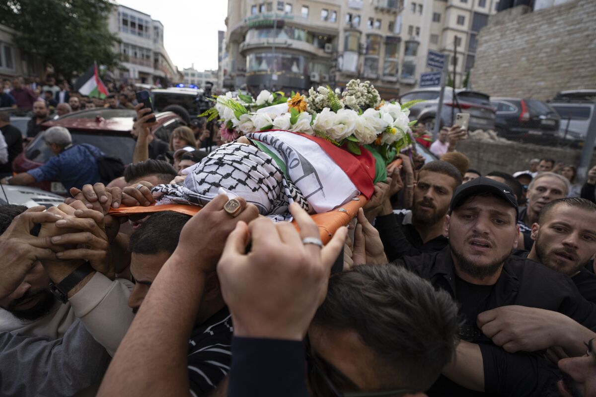 FILE - Palestinian mourners carry the body of Shireen Abu Akleh out of the office of Al Jazeera after friends and colleagues paid their respects, in the West Bank city of Ramallah, May 11, 2022. The Israeli military has identified a soldier's rifle that may have killed Al Jazeera journalist Shireen Abu Akleh, but said it cannot be certain unless the Palestinians turn over the bullet for analysis, a military official said Thursday, May 19, 2022. (AP Photo/Nasser Nasser, File)