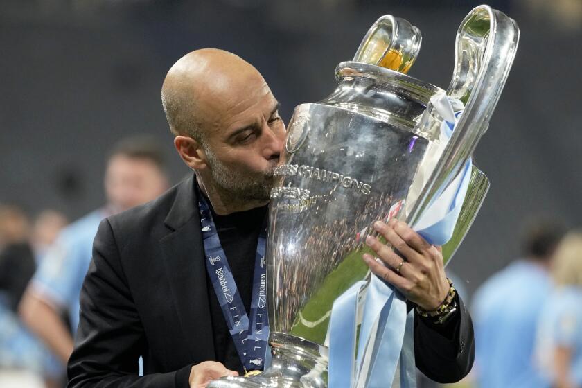 Manchester City coach Pep Guardiola kisses the trophy after winning the UEFA Champions League final 