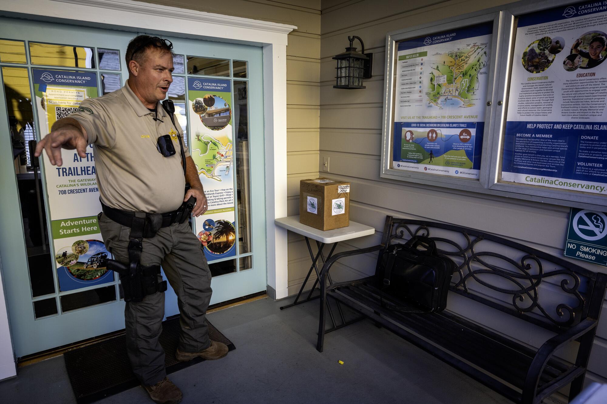 A sheriff's deputy gestures in the doorway of a building.