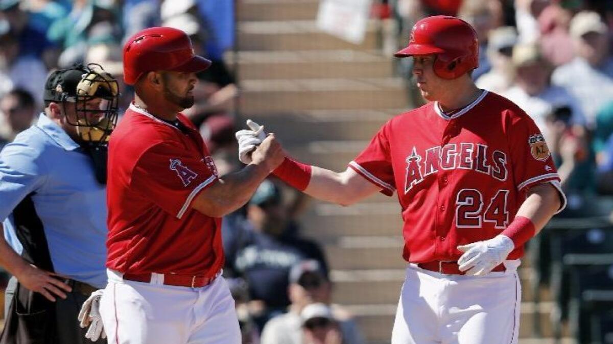 C.J. Cron, right, celebrates with Angels teammate Albert Pujols after hitting a home run against the Seattle Mariners in a spring-training game.