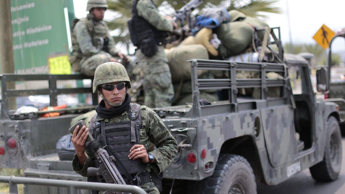 Mexican soldiers stand guard in Chilapa, Guerrero state, not too far from where two priests were shot dead on Feb. 5, 2018.