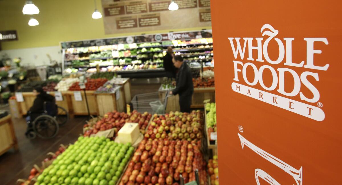 Shoppers browse the produce at a Whole Foods Market in Ohio in 2014. The grocery chain is preparing to launch its new, smaller-format 365 by Whole Foods Market stores targeting younger, more price-conscious shoppers.