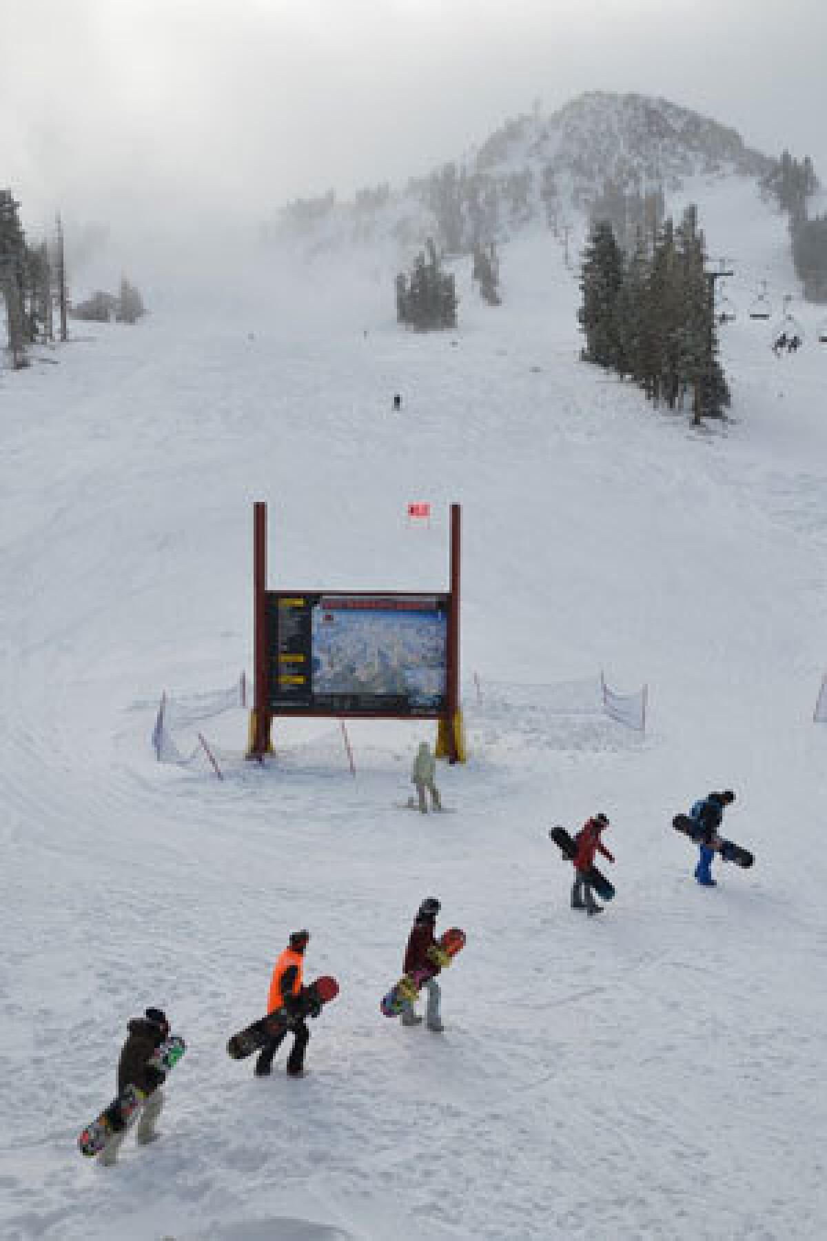 Snowboarders advance on the line for chair lift 1 at Mammoth Mountain.
