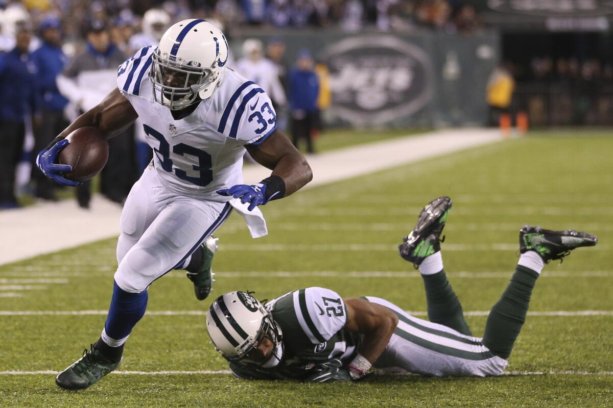 Colts running back Robert Turbin (33) dives in for a touchdown after avoiding a tackle by Jets cornerback Darryl Roberts (27) during the second half.