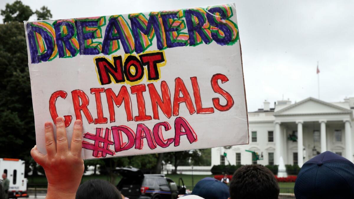 A woman holds a sign in support of the Obama administration program known as DACA during an immigration reform rally at the White House in Washington on Aug. 15.