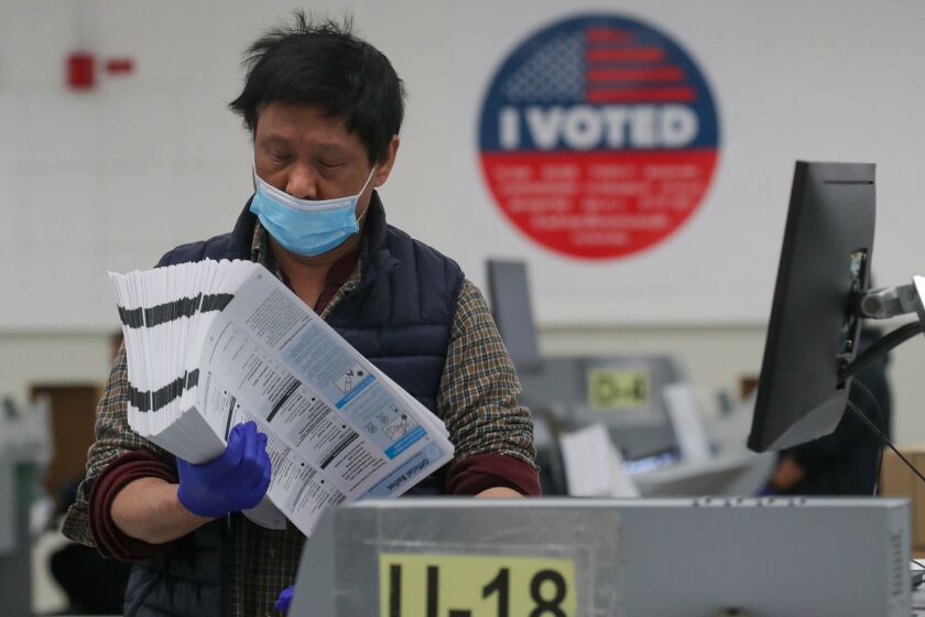 Downey, CA - November 11: Election assistant Derek Kim works on ballots scanning and tabulation of votes at Voting Solutions for All People (VSAP) Tally Room on Friday, Nov. 11, 2022 in Downey, CA. (Irfan Khan / Los Angeles Times)