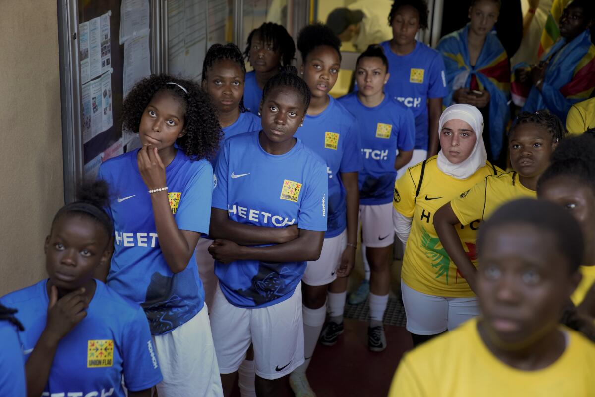 Players wait before entering the field prior to the final women's game of the national cup of working-class neighborhoods betwwen a team representing players with Malian heritage against one with Congolese roots, in Creteil, outside Paris, France, Saturday, July 2, 2022. This amateur tournament aims to celebrate the diversity of youth from low-income communities with high immigrant populations, areas long stigmatized by some observers and politicians as a breeding ground for crime, riots, and Islamic extremism. (AP Photo/ Christophe Ena)