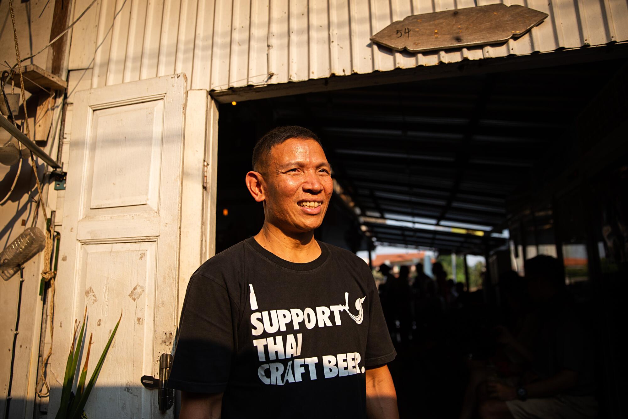 Wichit Saiklao stands at the entrance to Chit Beer, his brewhouse on Koh Kret island, Thailand.