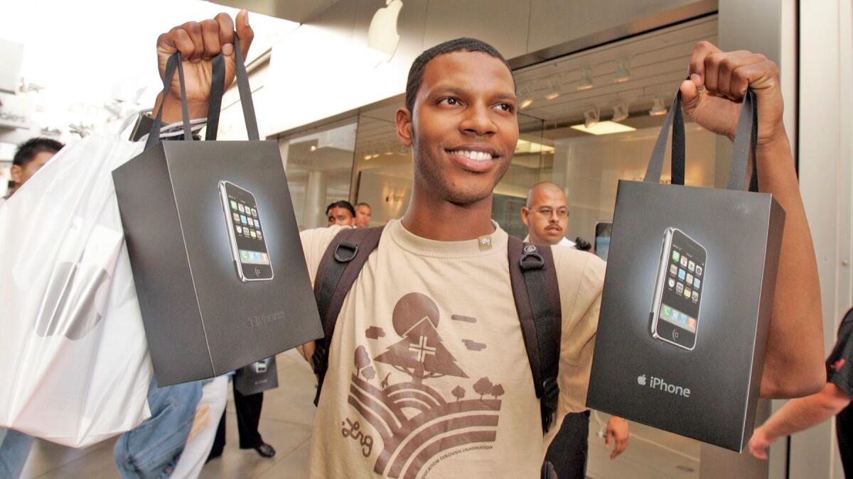 Nathan Alford with the two iPhones he bought for his boss as he leaves the Apple Store at the Westfield Century City on June 29, 2007.