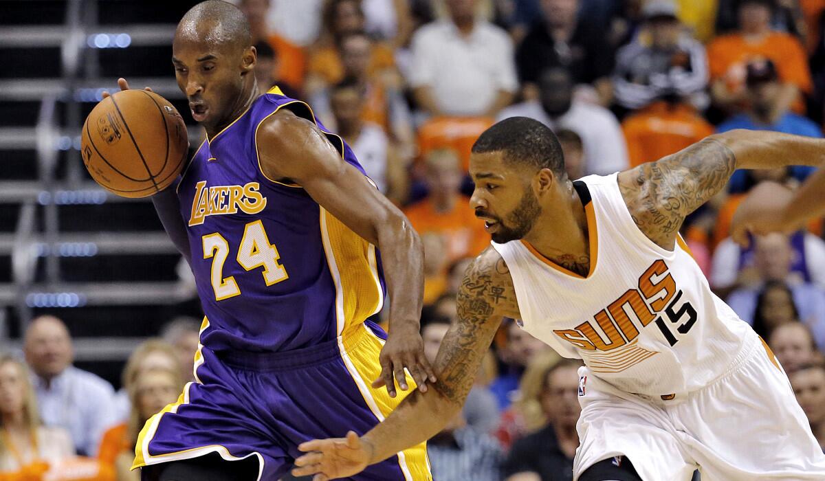 Lakers guard Kobe Bryant tries to prevent Suns forward Marcus Morris from stealing the ball while dribbling up the court in the first half Wednesday night in Phoenix.