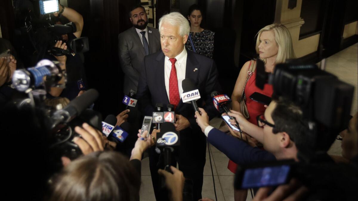 Republican gubernatorial candidate John Cox, center, speaks to reporters alongside his wife, Sarah Cox, in San Diego in June.