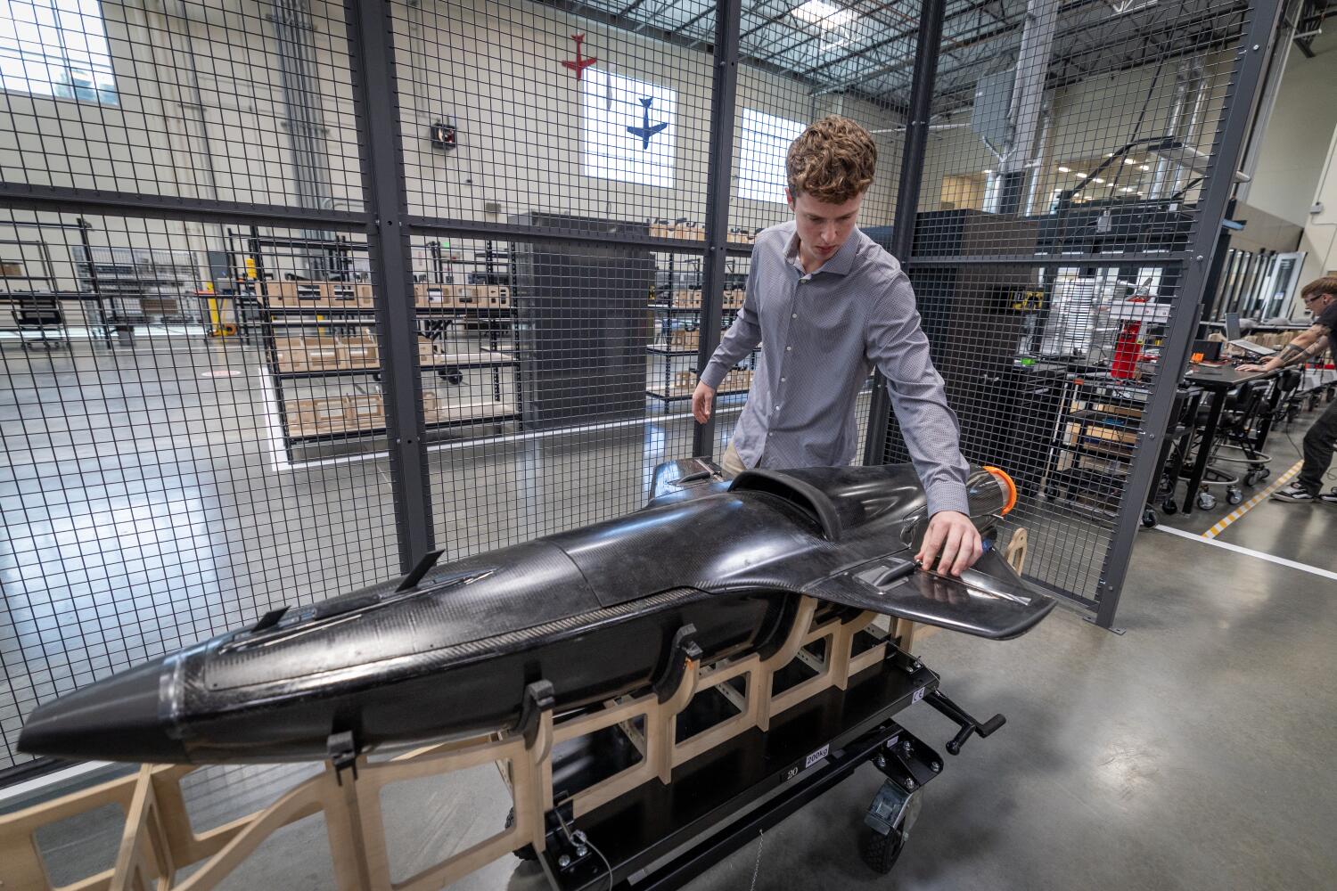 Huntington Beach, CA - September 11: Former Massachusetts Institute of Technology student Ethan Thornton, 21, founder of Huntington Beach-based defense tech startup Mach Industries, views their missile concept Viper, a VTOL strike aircraft designed to redefine air combat at the headquarters in Huntington Beach Thursday, Sept. 11, 2025. Mach Industries showcases their missile concept Viper, a VTOL strike aircraft designed to redefine air combat and the Glide, a high-altitude glider that delivers munitions across thousands of miles. (Allen J. Schaben / Los Angeles Times)