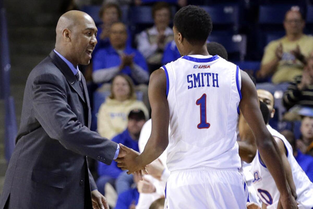 Tulsa Coach Danny Manning welcomes star forward Rashad Smith back to the bench for a breather during a game against North Texas earlier this season.
