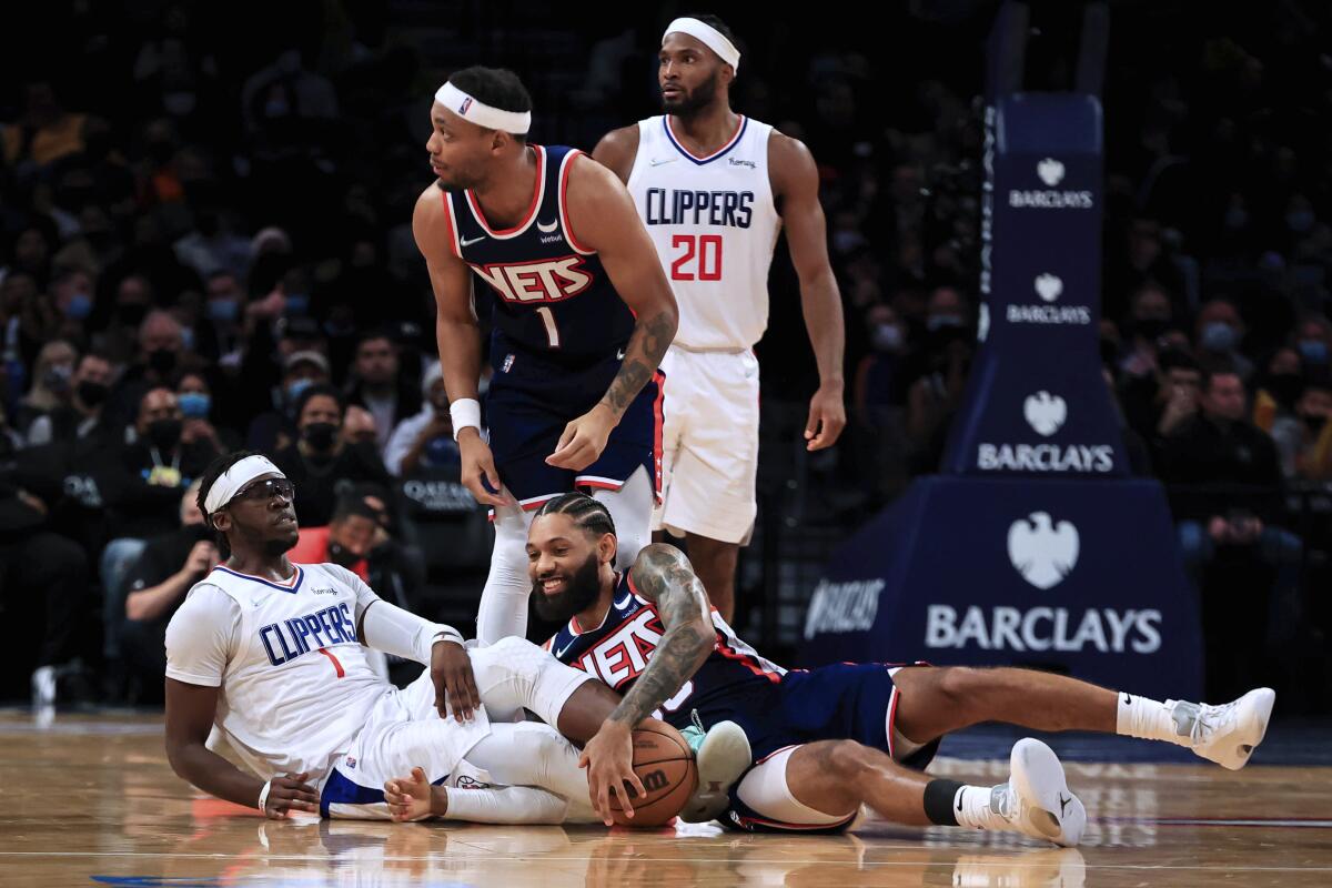 Clippers guard Reggie Jackson and Brooklyn Nets guard DeAndre' Bembry after scrambling for the ball.