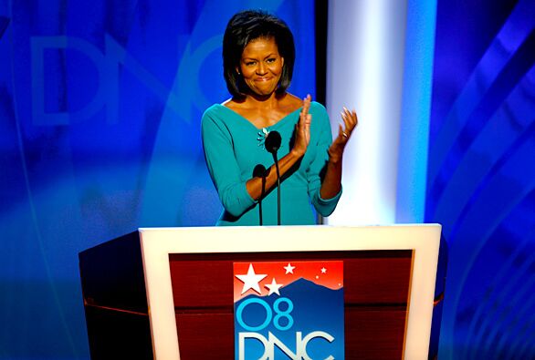 Michelle Obama stops and claps after mentioning former presidential candidate Hillary Rodham Clinton during her address on the first night of the Democratic National Convention.