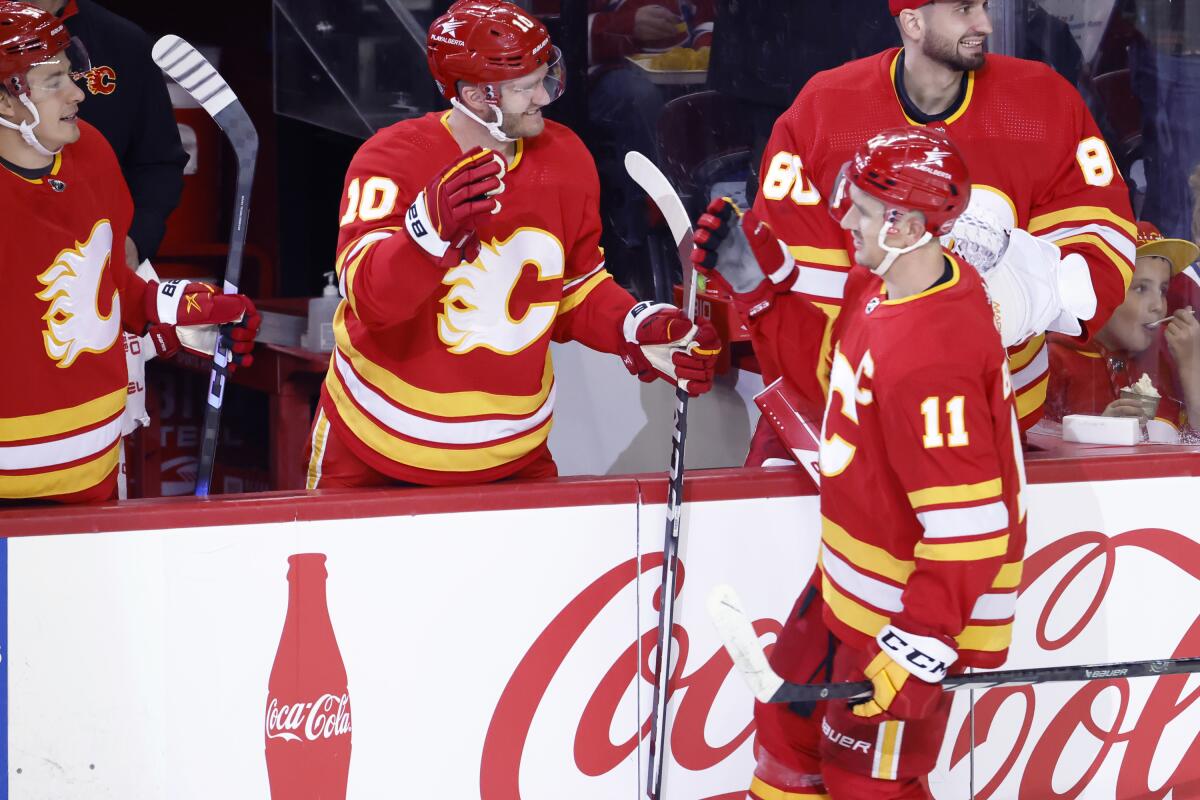 Calgary Flames' Mikael Backlund (11) celebrates his second goal against the Montreal Canadiens with teammate Jonathan Huberdeau (10) during second period NHL hockey action in Calgary, Alberta, Canada, Saturday, March 16, 2024. (Larry MacDougal/The Canadian Press via AP)