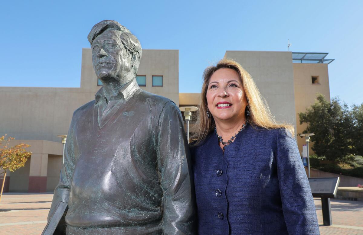Lorena Checa at Cal Stat State San Marcos with the school's statue of Cesar Chavez 