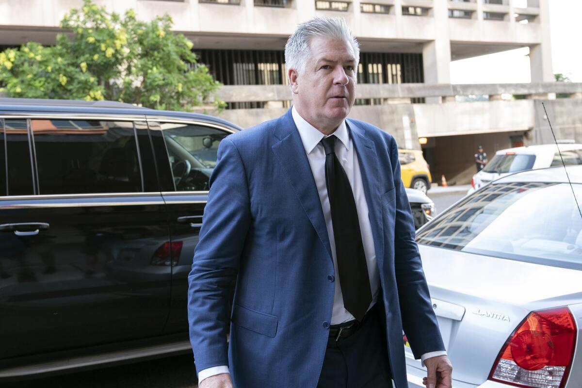 A man in a suit and tie walking away from a car