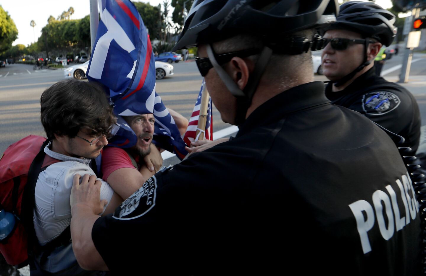 Beverly Hills police officers break up a scuffle between pro- and anti-Trump protesters gathered at the intersection of Sunset Boulevard and Benedict Canyon Road in Beverly Hills.