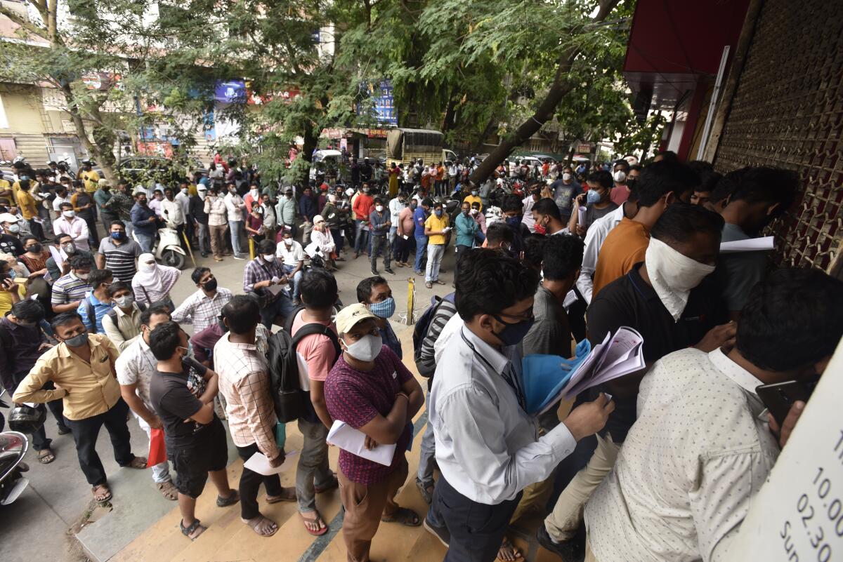 People wait in queues outside the office of the Chemists Association to demand necessary supply of the anti-viral drug Remdesivir, in Pune, India, Thursday, April 8, 2021. India is amid its worst pandemic surge, with over 100,000 cases in the past 24 hours. And experts concur that the worst is yet to come. Hospitals across the country, particularly in western Maharashtra state, are starting to get overwhelmed with patients. (AP Photo)
