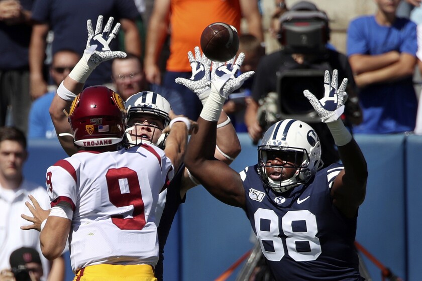 BYU players pressure USC quarterback Kedon Slovis during the first half of Saturday’s game.