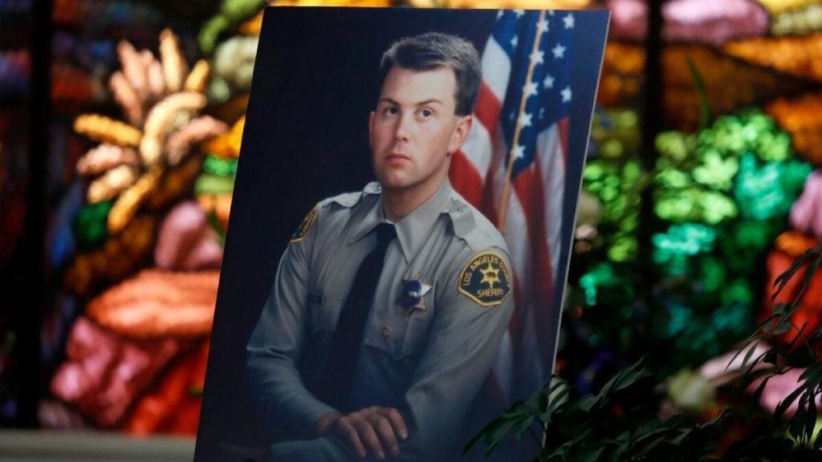 A picture of L.A. County Sheriff's Deputy Steven Belanger, shot in the head during a vehicle stop in 1994, is on display at his funeral in February; he died of complications from his injuries. He's among the peace officers being honored during a memorial torch relay this weekend.