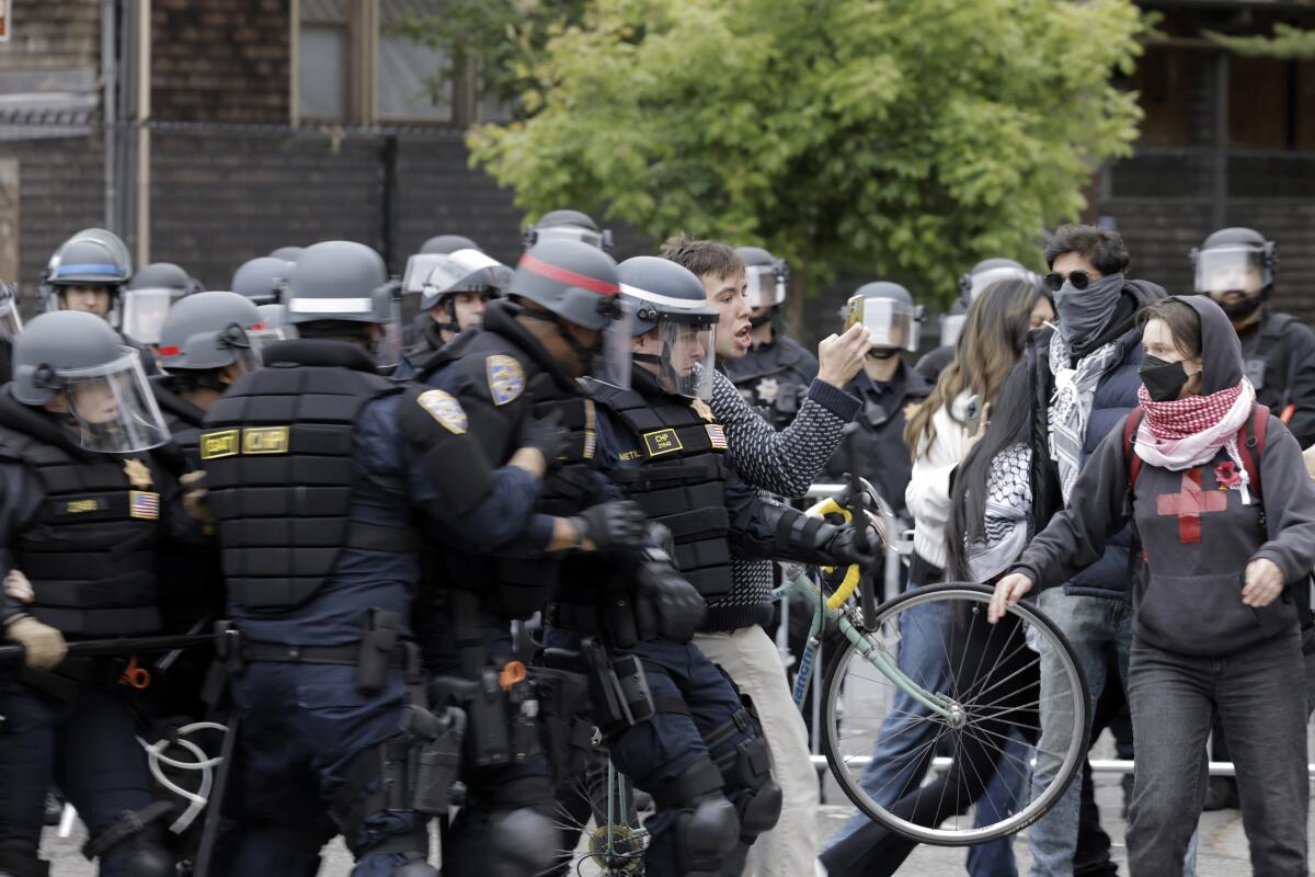 Law enforcement officers in riot gear block protesters in Berkeley