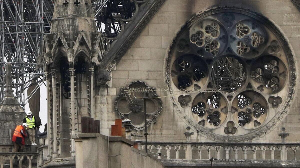 Experts inspect the damaged Notre Dame Cathedral in Paris after the devastating fire. It will take decades to restore the historic structure.