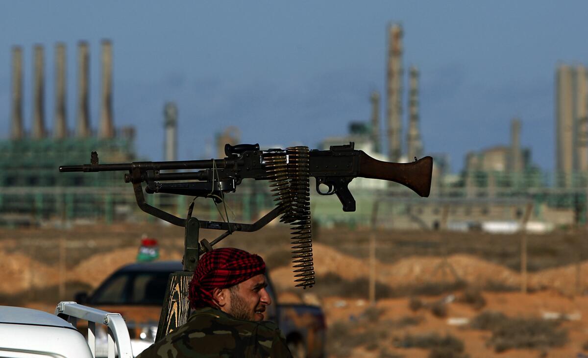 A rebel fighter guards the oil refinery in Ras Lanuf, Libya, in 2011.