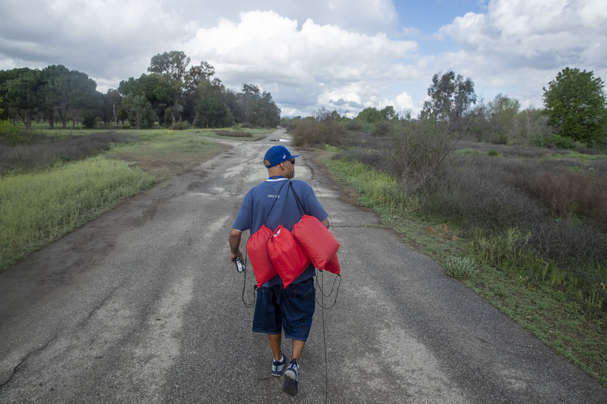 LA Family Housing outreach coordinator Eric Montoya walks out into the Sepulveda Dam Recreation Area to conduct interviews with homeless people camped in the Sepulveda Basin in Encino.
