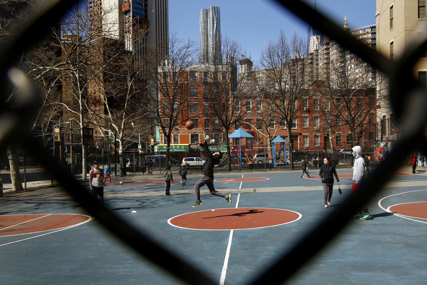 Children play basketball on the edge of New York's Chinatown, where there is a mix of cultures.