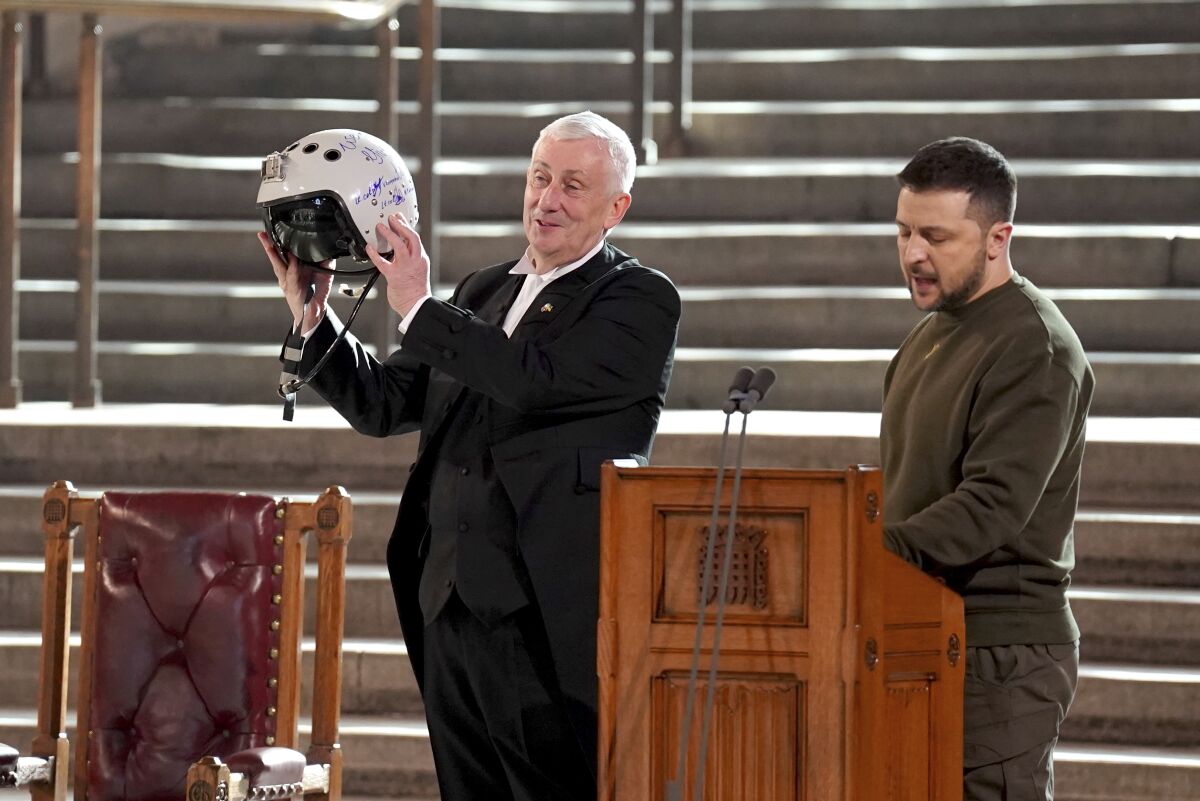 Speaker of the House of Commons, Sir Lindsay Hoyle, holds a Ukrainian helmet.