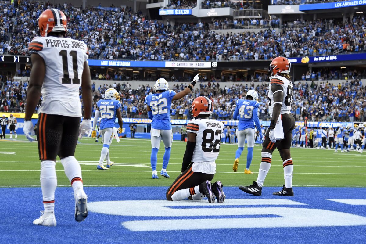 Cleveland Browns player kneel and stand in the end zone after a failed Hail Mary pass to end an NFL football game against the Los Angeles Chargers Sunday, Oct. 10, 2021, in Inglewood, Calif. (AP Photo/Kevork Djansezian)