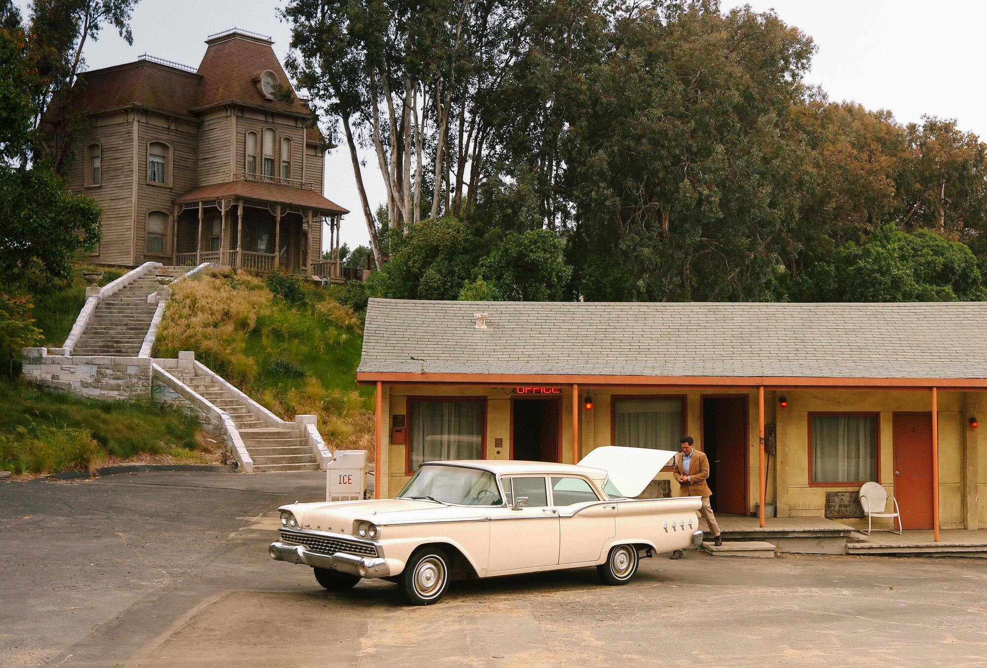 A low-slung motel below a Gothic residence.