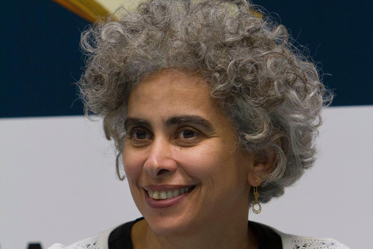 A smiling woman with curly gray hair