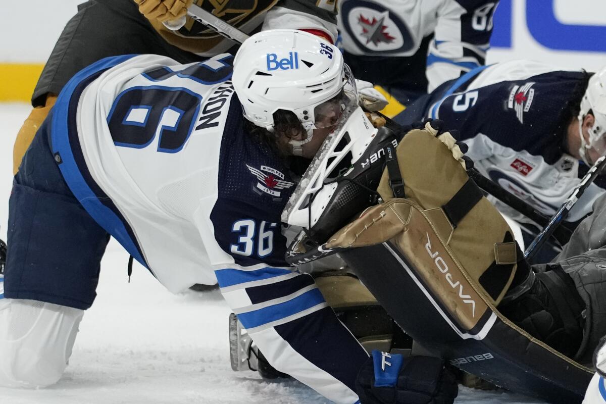 Winnipeg center Morgan Barron cuts his face cut on the skate of Golden Knights goaltender Laurent Brossoit 