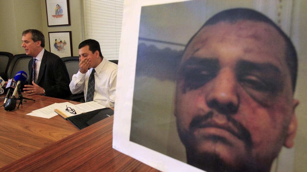 Gabriel Carrillo, right, listens to attorney Ronald Kaye speak about Los Angeles County's $1.175-million civil lawsuit settlement with Carrillo during a news conference in May 2014.