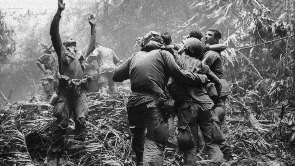 In an April 1968 photo, a first sergeant of A Company, 101st Airborne Division, guides a medevac helicopter through the jungle foliage to pick up casualties suffered during a five-day patrol near Hue, South Vietnam.