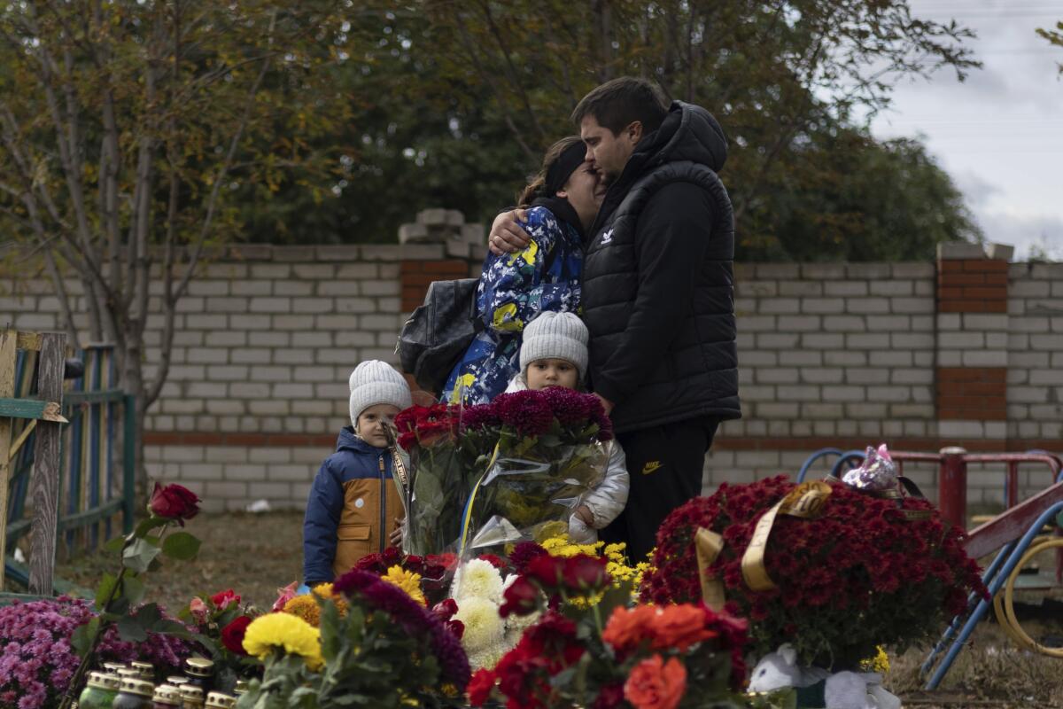 Couple embracing near memorial for victims of Russian rocket near Kharkiv, Ukraine