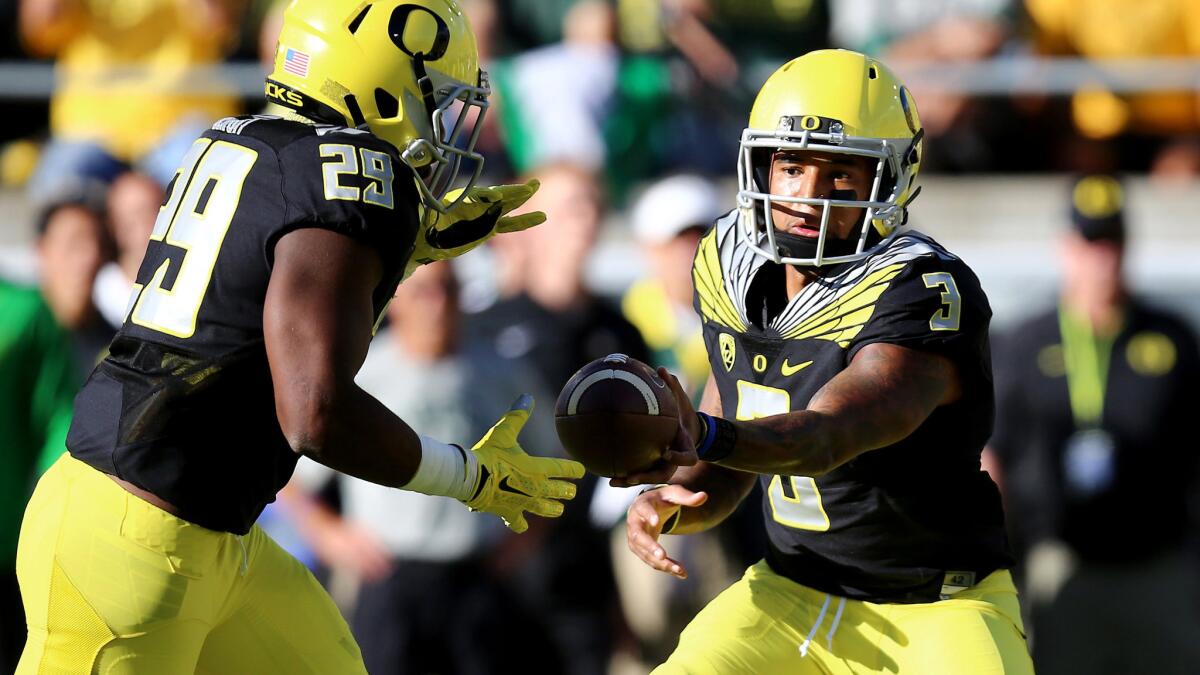 Oregon quarterback Vernon Adams Jr. (3) hands off to running back Kani Benoit (29) in the first quarter of their game against Eastern Washington on Saturday in Eugene, Ore.