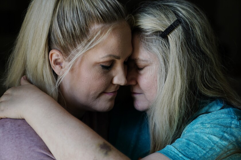 Angel Campbell, 37, left, embraces her mother Patricia Collins, 58, right, on Thursday, Aug. 4, 2022, in Chavies, Ky. Collins was badly injured in massive flooding. Campbell says they lost her grandmother in the same house as Collins. Campbell says that her mother and grandmother were both standing on a table as the water swept them both away. Collins survived with injuries while her mother Nellie Mae Howard, died in the flood. (AP Photo/Brynn Anderson)