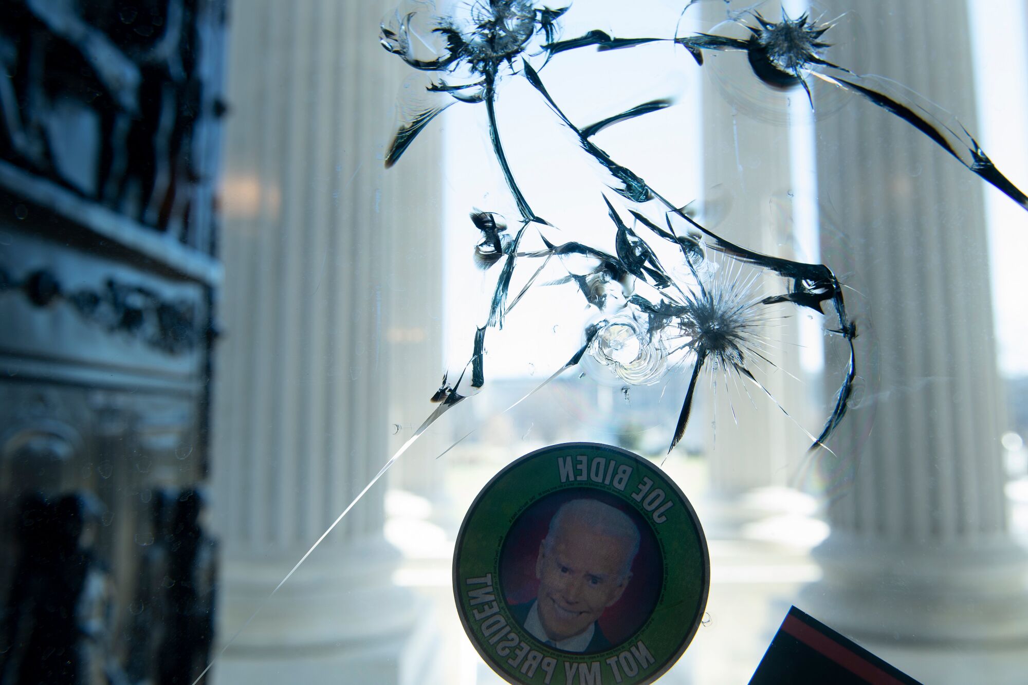 An anti-Biden sticker is seen on a cracked window a day after a pro-Trump mob broke into the US Capitol Thursday