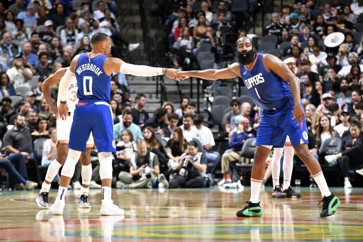 Clippers' Russell Westbrook, left, acknowledges James Harden in a game against the San Antonio Spurs on Nov. 20, 2023.