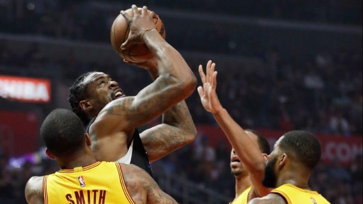 Clippers center DeAndre Jordan powers through a crowd of Cavaliers defenders during first half of a game on March 18 at Staples Center.